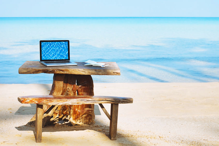 Laptop and desk facing the ocean